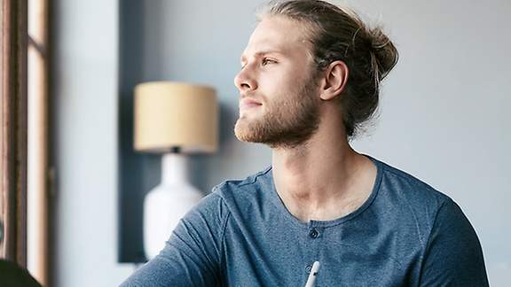 Krankentagegeld für Gewerbetreibender: Gewerbetreibender Mann am Fenster