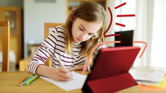 Ein Mädchen sitzt zu Hause am Schreibtisch und lernt