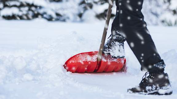 Eine Person schippt Schnee.