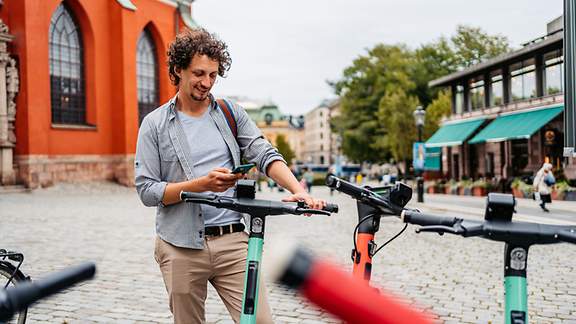 Junger männlicher Tourist, der ein Elektrofahrrad mietet