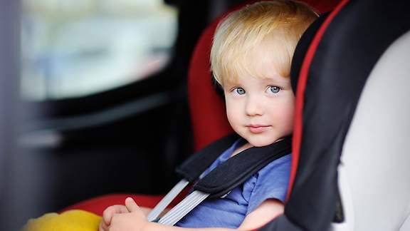 Kleinkind sitzt angeschnallt im Kindersitz