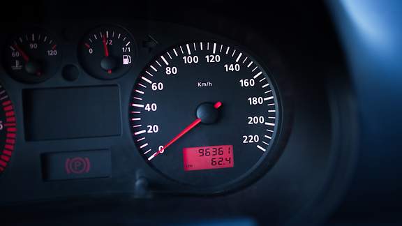Armaturenbrett mit Geschwindigkeits- und Kilometerzähler zeigt Kilometerstand eines Autos an.