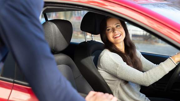 Mann spricht mit junger Frau in einem Auto 