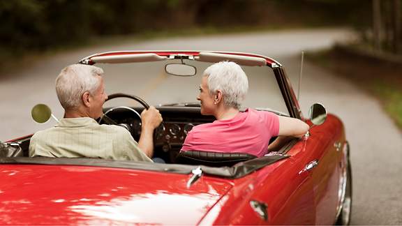 Älteres Paar macht mit dem Cabrio eine Spritztour.