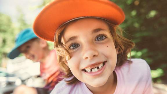 Ein lachender Junge zeigt sein Milchzahn-Gebiss mit etlichen Zahnlücken