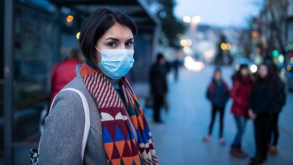 Frau mit Atemschutzmaske in der Fußgängerzone