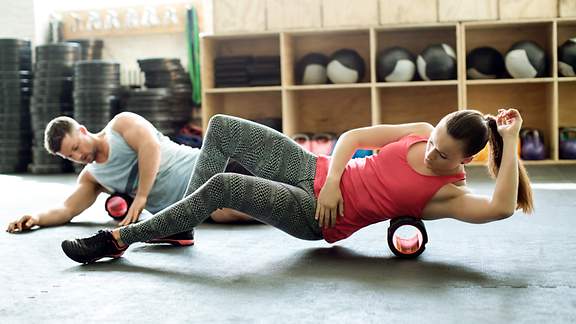 Mann und Frau beim Faszientraining im Gym