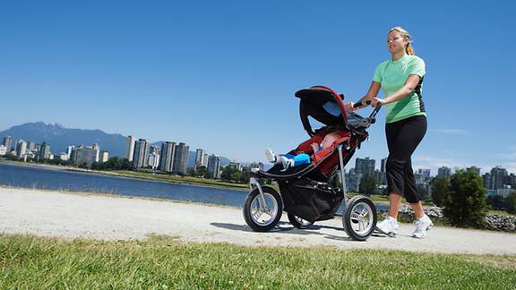 Frau joggt mit Kinderwagen