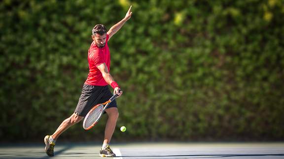 Ein Tennisspieler schlägt eine Vorhand