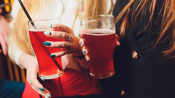 Zwei Frauen halten Gläser mit Mixgetränken in der Hand