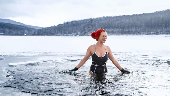 Ältere Frau badet im eiskalten Wasser eines Sees