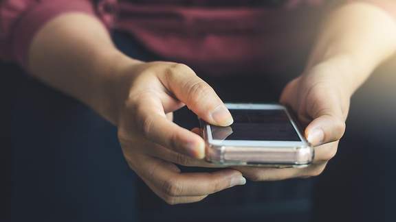 Eine Person hält ein Handy in den Händen