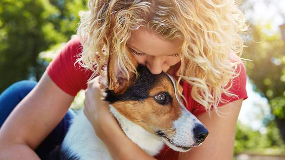 Eine Frau umarmt ihren Hund