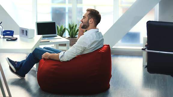 Mann sitzt in ergonomischem Stuhl 