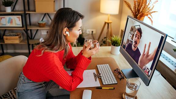 Eine Frau nimmt zu Hause an einer Videokonferenz teil