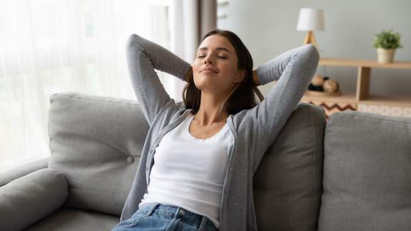 Eine junge Frau entspannt auf dem Sofa