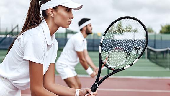 Gemischtes Tennis-Doppel erwartet fokussiert den gegnerischen Aufschlag