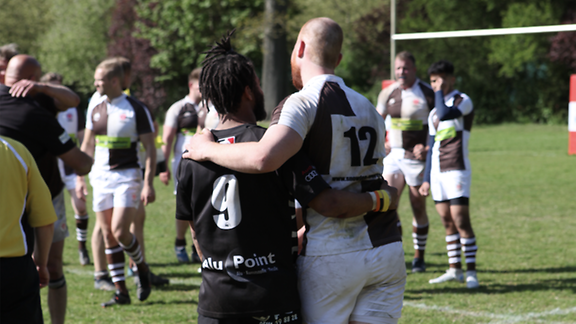 Rugby-Spieler umarmen sich freundschaftlich nach dem Spiel