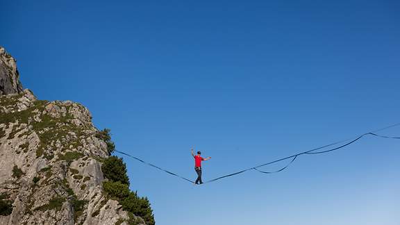 Friedi Kühne balanciert auf der Slackline in luftiger Höhe