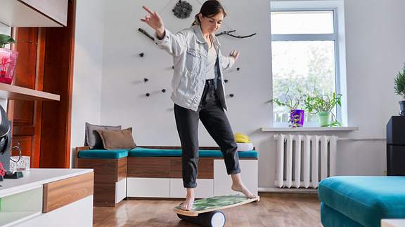 Frau mittleren Alters auf Fitness-Balance-Board