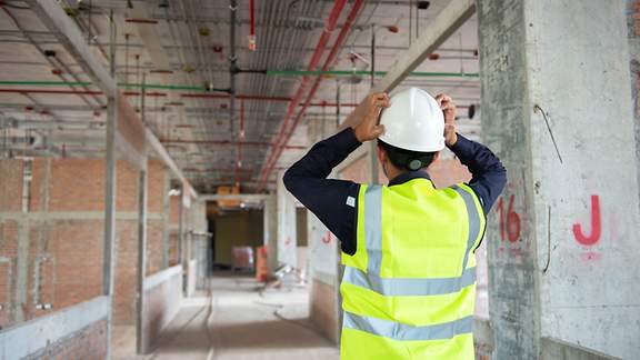 Baustellenleiter blickt verzweifelt auf einen Rohbau