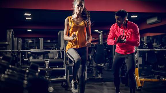 Fokussierte junge Sportlerin beim Aufwärmtraining in der Sporthalle mit ihrem Trainer