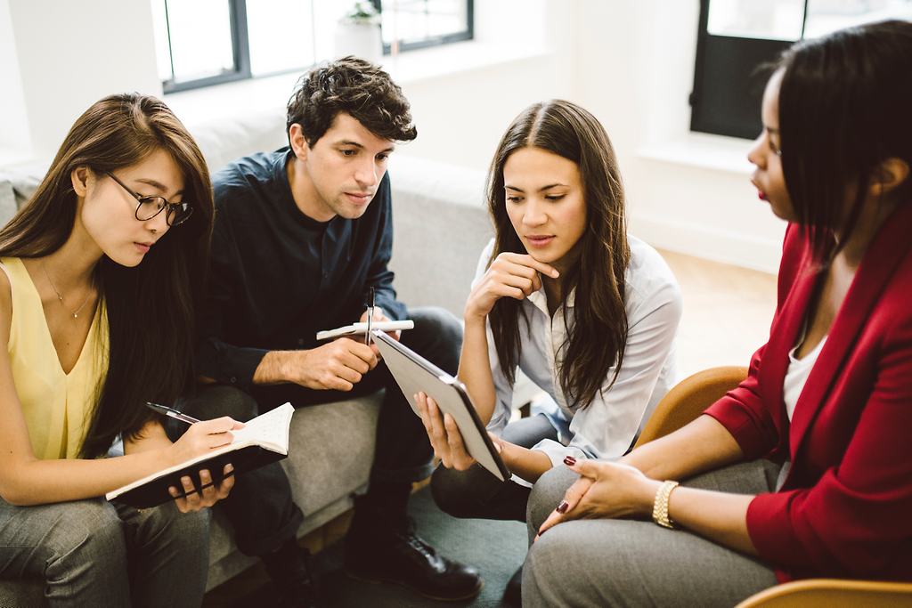Junge Menschen in Gesprächen und Teamsituationen während ihrer kaufmännischen Ausbildung