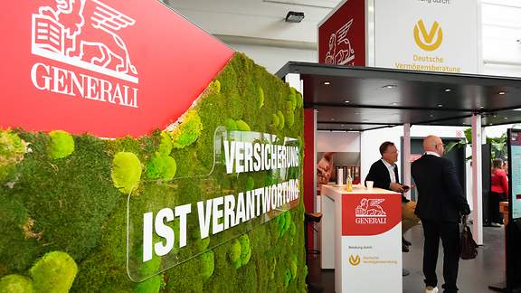 Der Generali-/DVAG-Stand im Profil. Das Motto "Versicherung ist Verantwortung" steht an einer grünen Mooswand.